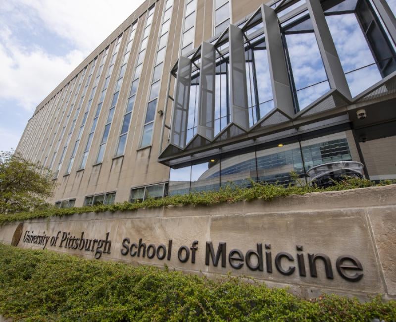 A sign in front of Scaife Hall reading "51ƷƵ School of Medicine"