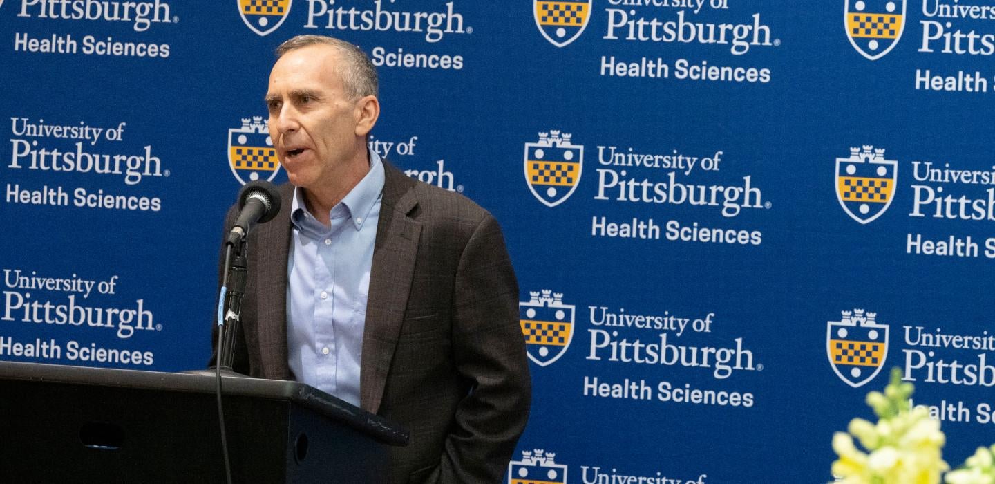 Michel Boninger speaks in front of a 51ƷƵ Health Sciences logo 