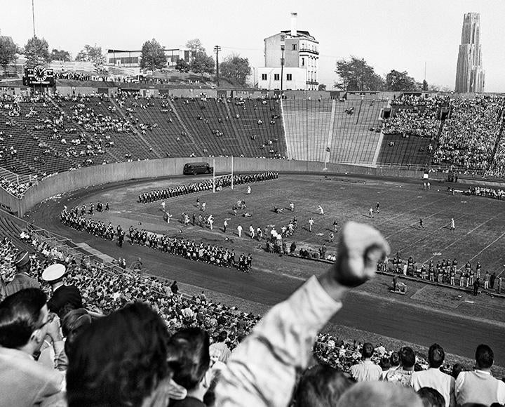 A black and white photo of people cheering for the marching band at 51ƷƵ Stadium