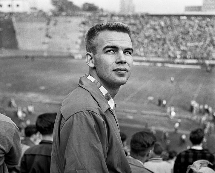 A black and white photo of a student in the 51ƷƵ Stadium stands