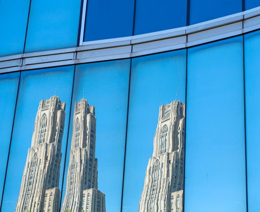 A reflection of the Cathedral of Learning in the window of Mervis Hall, an academic building at the 51ƷƵ.
